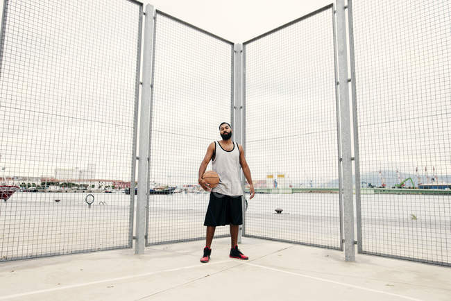 Homme confiant posant avec le basket — Photo de stock