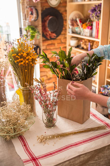 Cultivateur composant des fleurs en sac — Photo de stock