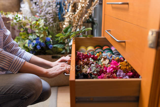 Woman in craft shop choosing flowers — Stock Photo