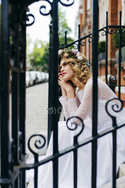 Pensive woman in chaplet and gown — Stock Photo