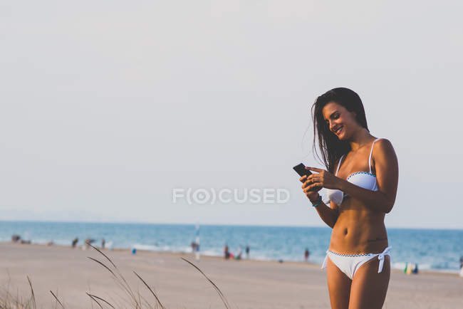 Happy brunette using mobile phone — Stock Photo