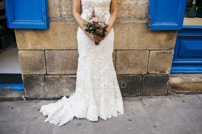 Женщина на поле с свадебным букетом — стоковое фото