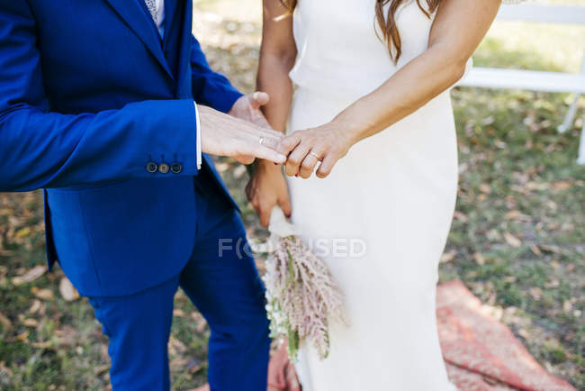 Wedding couple holding hands — Stock Photo