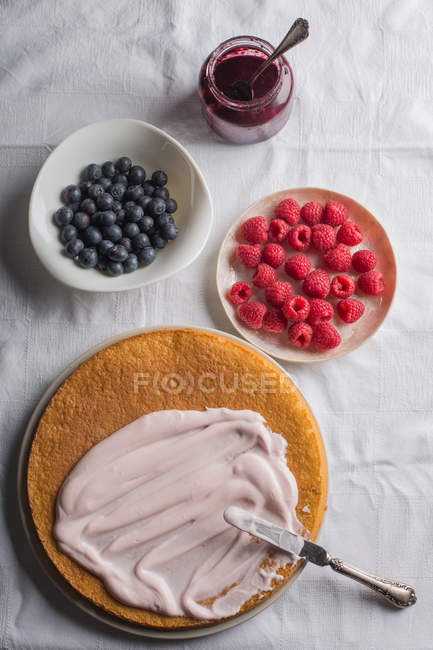 Preparación de pastel de bayas con glaseado de yogur - foto de stock