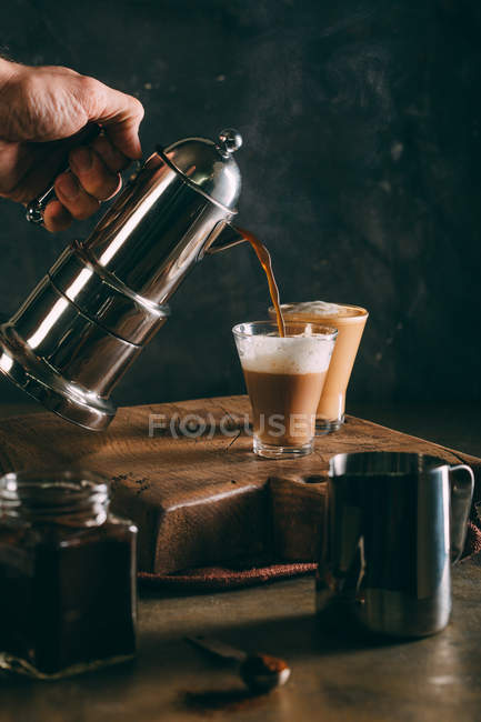 Verter café caliente en vidrio - foto de stock