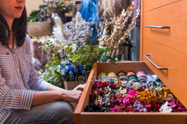 Frau im Bastelladen wählt Blumen aus — Stockfoto