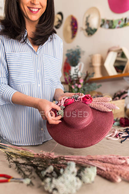 Жінка-майстер тримає прикрашений капелюх — стокове фото