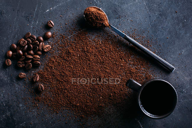 Café en grains et café moulu sur fond sombre — Photo de stock