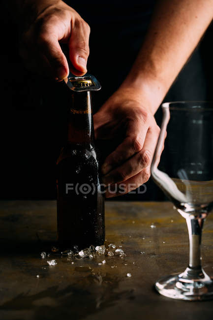 Hombre abriendo una botella de cerveza fría - foto de stock