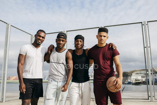 Equipo de baloncesto posando en suelo callejero - foto de stock
