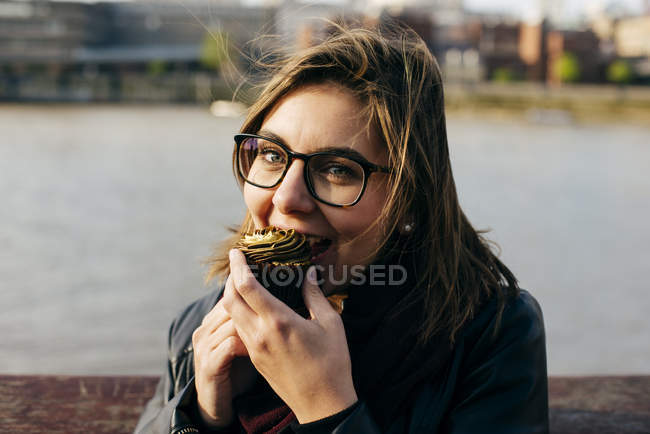 Жінка кусатися кекс — стокове фото