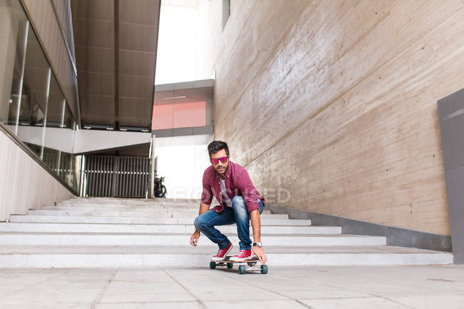 Homme à la mode équitation skateboard — Photo de stock