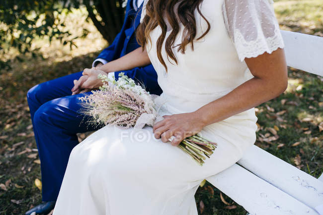 Crop bride and groom on bench — Stock Photo