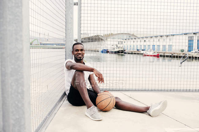 Homem confiante sentado com basquete — Fotografia de Stock