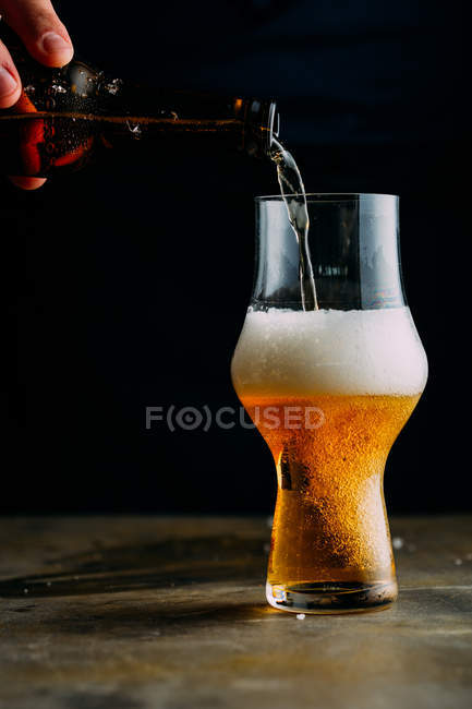 Uomo che serve un bicchiere di birra fredda — Foto stock