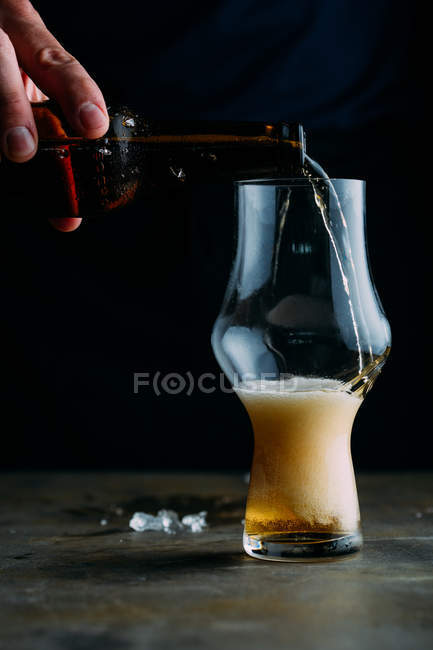 Homem que serve um copo de cerveja gelada — Fotografia de Stock