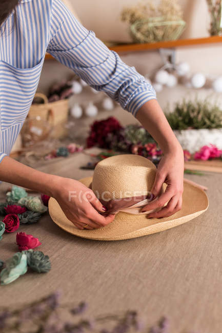 Crop persona decorazione cappello con fiori — Foto stock