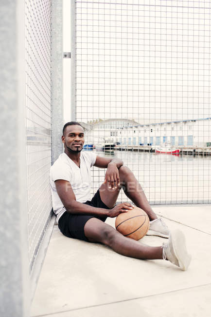 Homme confiant assis avec le basket — Photo de stock