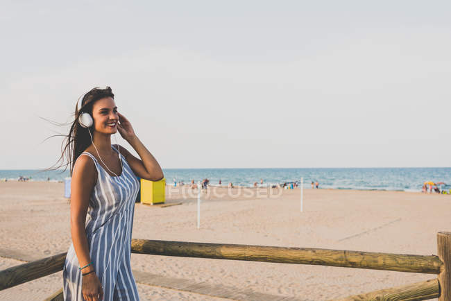 Женщина слушает музыку на пляже — стоковое фото