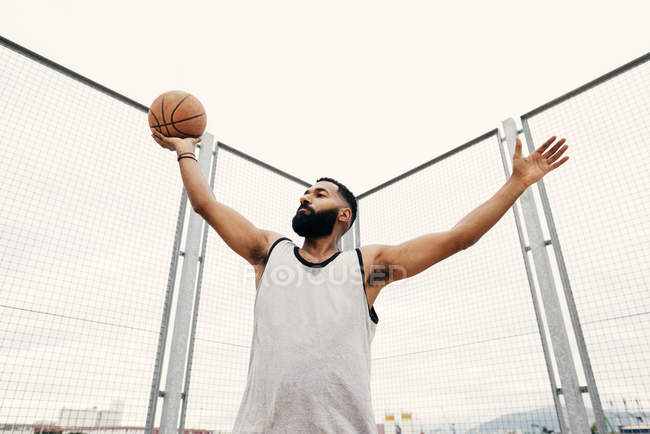 Впевнений чоловік позує з баскетболом — стокове фото