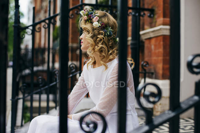 Splendida donna sui gradini in abito bianco — Foto stock