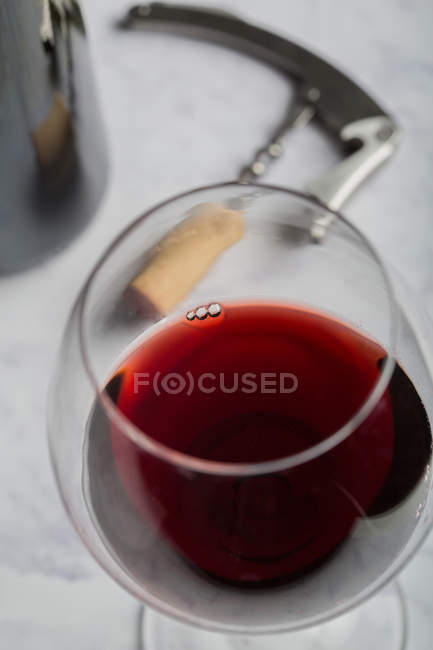 Vinho tinto e vidro na mesa de mármore — Fotografia de Stock