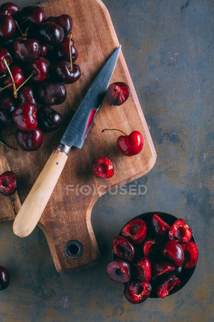 Cerejas em uma tábua de corte de madeira — Fotografia de Stock