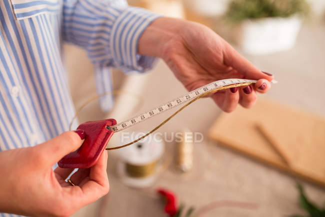 Woman measuring off ribbon for headband — Stock Photo