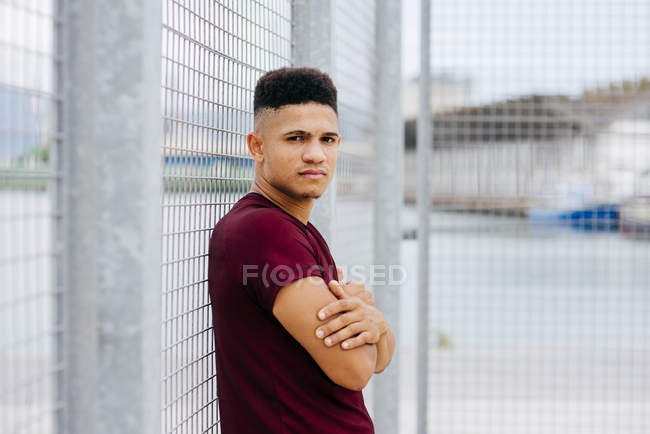 Young sportive man posing in squat — Stock Photo