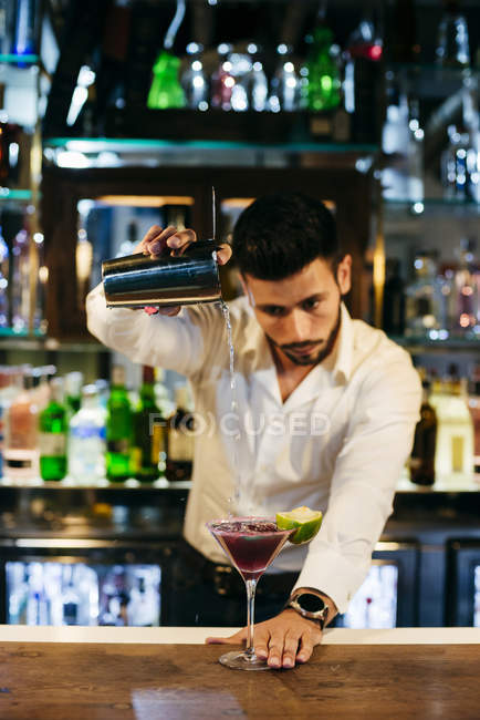 Bartender pouring cocktail — Stock Photo