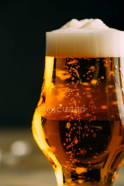 Glass of cold beer on dark — Stock Photo