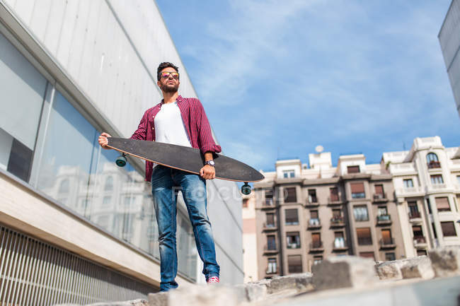 Homme élégant posant avec longboard — Photo de stock