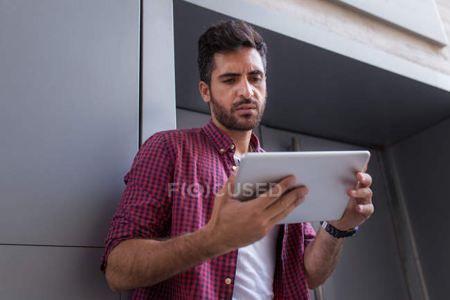 Handsome man with tablet on street — Stock Photo