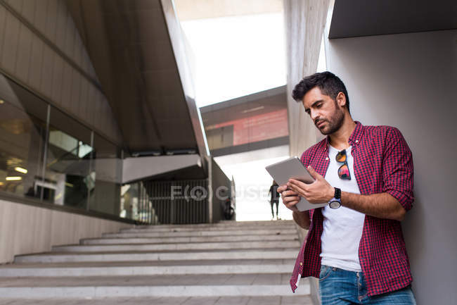 Handsome man with tablet on street — Stock Photo