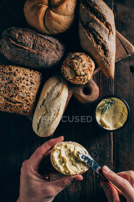 Homem espalhando manteiga no pão — Fotografia de Stock