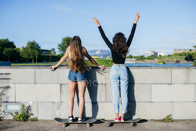 Vista posterior de las niñas en patines - foto de stock