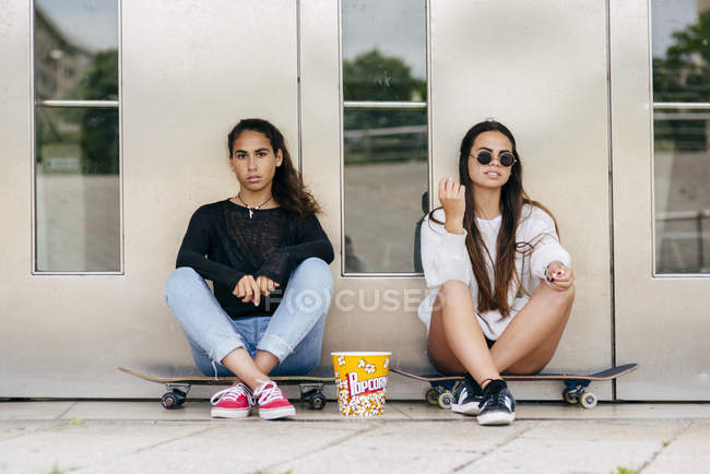 Adolescentes elegantes com pipoca em patins — Fotografia de Stock
