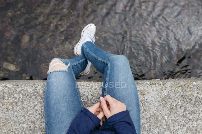 Meninas pernas penduradas sobre o mar — Fotografia de Stock