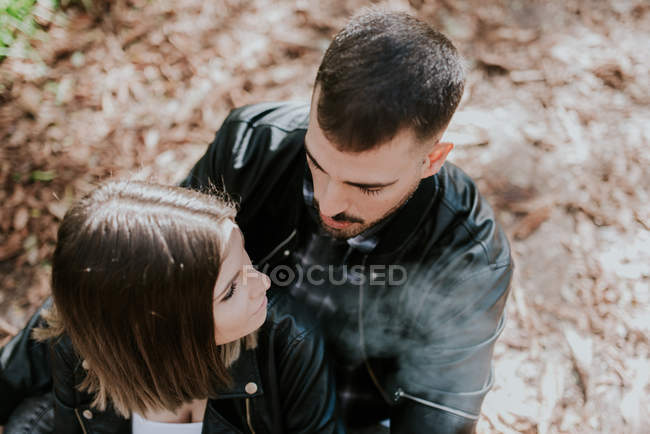 Mann umarmt Frau im Park von hinten — Stockfoto