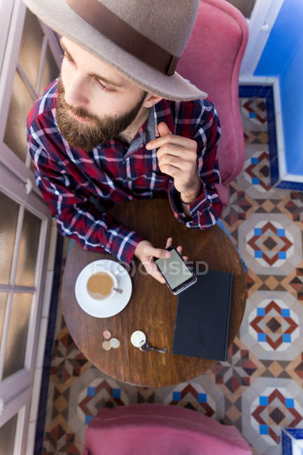 Hombre de sombrero con teléfono y café . - foto de stock