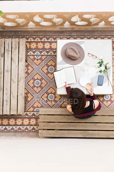 Female in cafe with book — Stock Photo