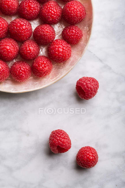 Raspberries on marble table — Stock Photo