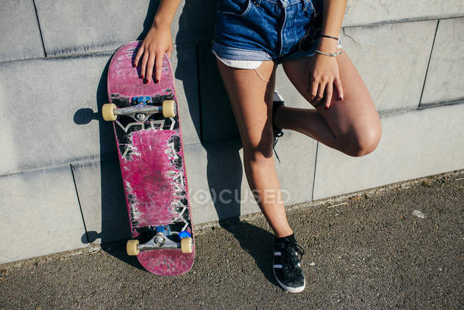 Девушка с урожая позирует со старым скейтом — стоковое фото