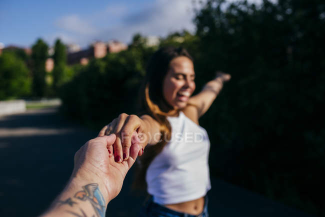 Girl holding anonymous hand and smiling — Stock Photo