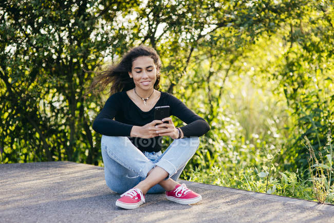 Smiling youngster with smartphone — Stock Photo
