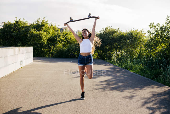 Счастливая девушка держит коньки над головой — стоковое фото