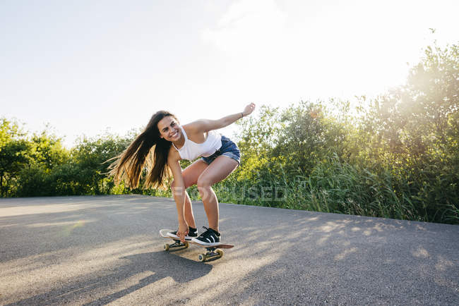 Adolescente monopatín a la luz del sol - foto de stock