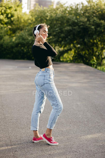 Content girl listening to music outside — Stock Photo