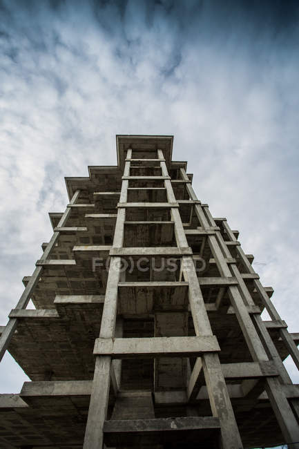 Bottom view of unfinished building with concrete structure over blue sky — Stock Photo