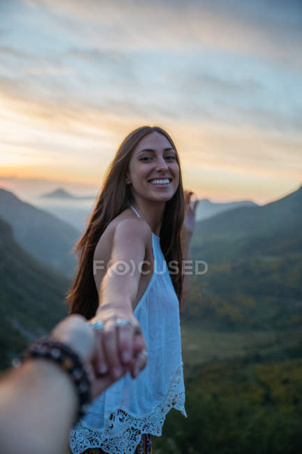 Chica alegre gesto sígueme en el paisaje de montaña - foto de stock
